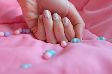 Granit gri çivi. Pembe battaniye arka plan üzerinde renkli boncuk boyasıyla çivi kadar kapatın