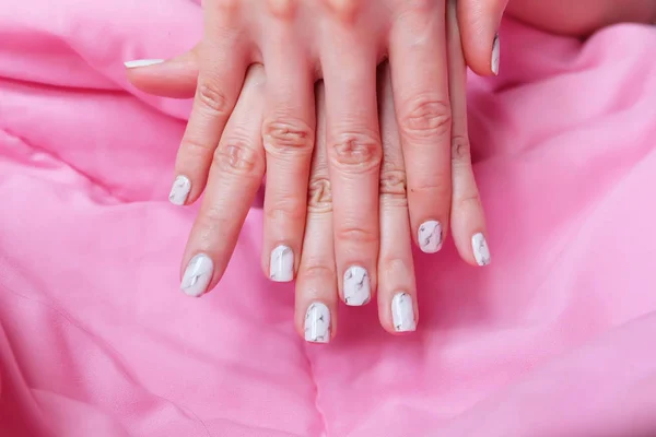 Granito Gray Nail. Close Up unhas polonês, Manicure granito cinza prego no fundo cobertor rosa — Fotografia de Stock