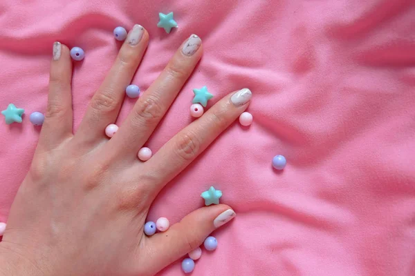 Granit gri çivi. Pembe battaniye arka plan üzerinde renkli boncuk boyasıyla çivi kadar kapatın