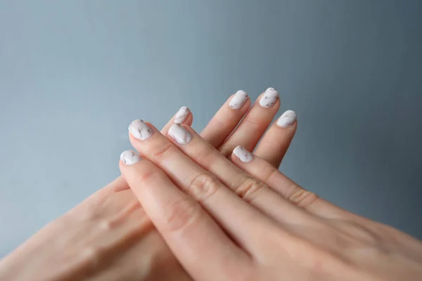 Hermoso esmalte de uñas, clavo de manicura. Primer plano uñas de granito gris en el fondo — Foto de Stock