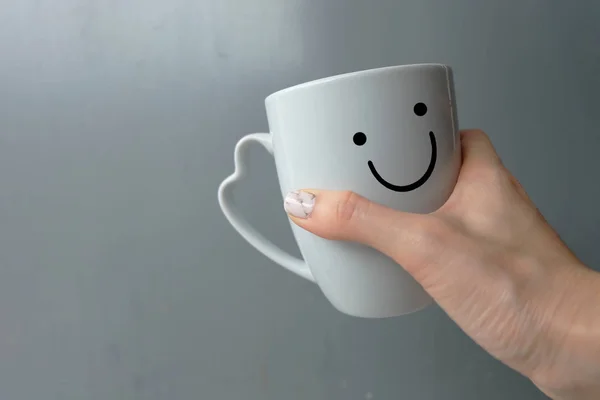 Woman Holding Happy Smile White Cup of Coffee. Close Up Granite Gray Nail Polish on the Background