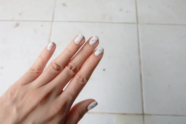 Hermoso esmalte de uñas, clavo de manicura. Primer plano uñas de granito gris sobre el fondo blanco — Foto de Stock
