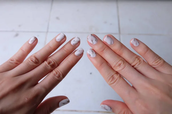 Prachtige nagellak, Manicure, nagel. Close-up van graniet grijs nagels op de witte achtergrond — Stockfoto