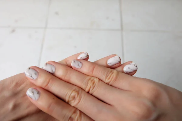 Bellissimo Smalto, Unghie Manicure. Chiodi grigio granito da vicino sullo sfondo bianco — Foto Stock