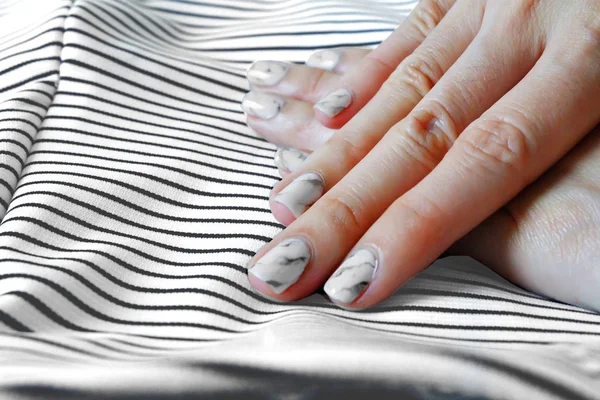 Ruce a nehty, manikúra nehty. Close Up žula šedá nehty s pozadím Fabric a černobílými — Stock fotografie