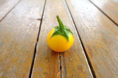 Tek sarı patlıcan. Ahşap masa arka plan sarı taze patlıcan Tay kadar kapatın