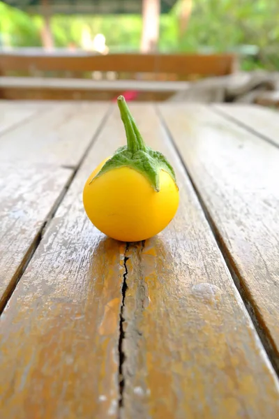 Tek sarı patlıcan. Ahşap masa arka plan sarı taze patlıcan Tay kadar kapatın