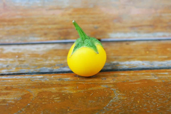 Tek sarı patlıcan. Ahşap masa arka plan sarı taze patlıcan Tay kadar kapatın