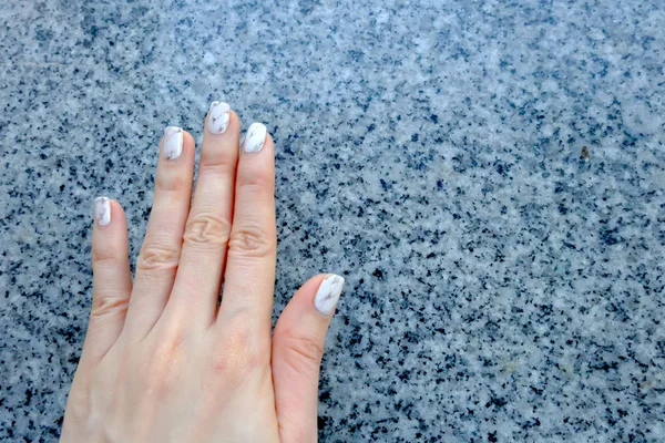 Rąk i paznokci, Manicure paznokci. Zbliżenie granit szary paznokcie na tle granitu — Zdjęcie stockowe