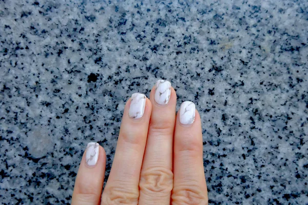 Esmalte de uñas y manicura. Primer plano uñas de granito gris sobre fondo de granito — Foto de Stock