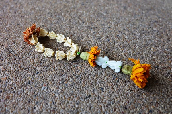 Gamla Jasmin Garland, torkade Jasmin krans med Marigold isolerade på marken bakgrund — Stockfoto