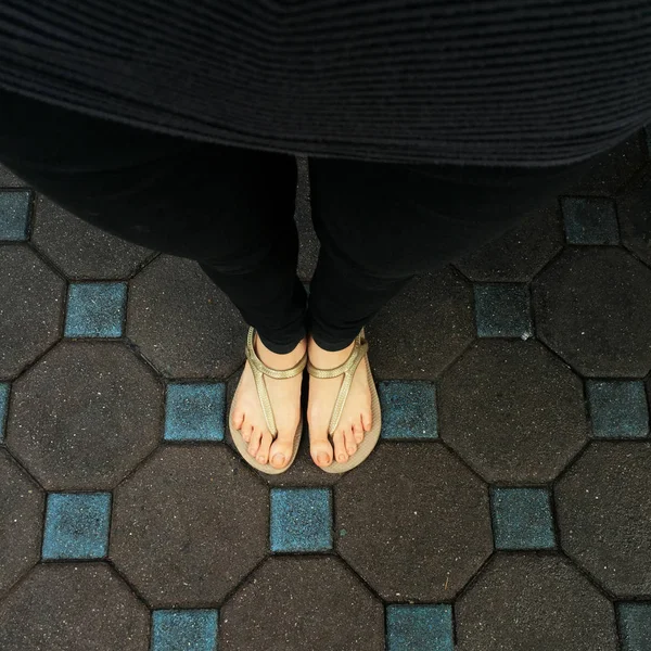 Selfie ženské nohy nosí sandály a černé džíny na pozadí dlaždic — Stock fotografie