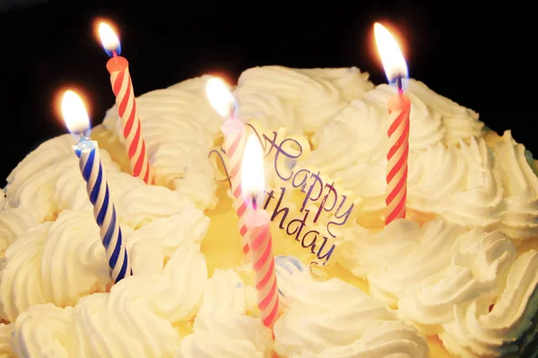 Bolo de aniversário feliz com cores de velas e fundo de luzes brilhantes — Fotografia de Stock