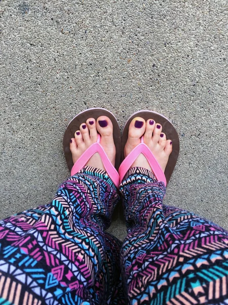 Sandal, Close Up on Girl\'s Violet Nail and Feet Wearing Pink Sandals on the Street Background