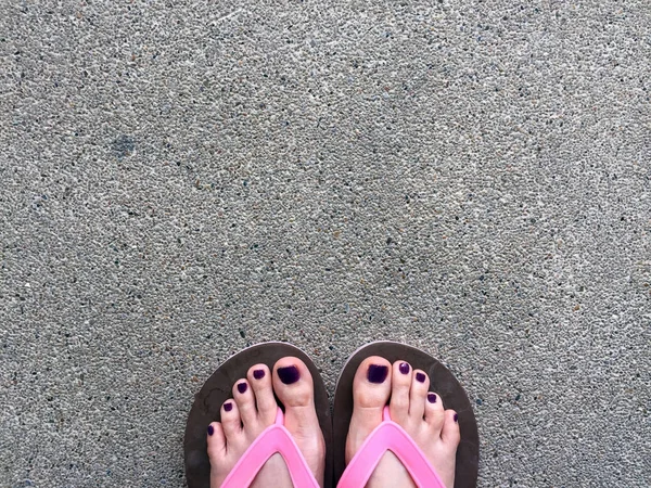 Sandal, kapatmak kız mor çivi ve çimento zemin zemin üzerine pembe sandalet giyen ayakları üzerine