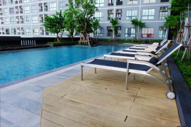 Mavi yüzme havuzuyla boş sandalyeler, havuzu sandalye Relax arka plan için