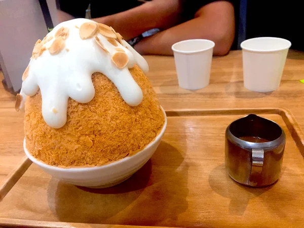 Bingsu Milch Tee koreanisches Dessert mit Tee-Topping und Erdnuss auf Holzteller Hintergrund — Stockfoto