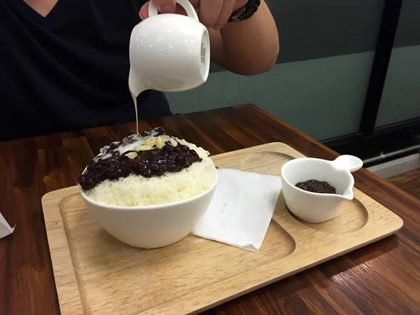 Koreaans dessert-Bingsu Red Bean Ice Shave met pinda en gieten van melk op houten tafel achtergrond — Stockfoto