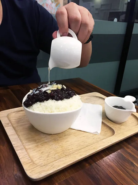 Sobremesa coreana - Barbear de gelo de feijão vermelho Bingsu com amendoim e derramamento de leite em fundo de mesa de madeira — Fotografia de Stock