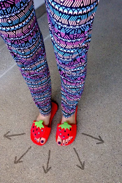 Lady 's Feet Violet Nail Verniz em sandálias de morango com seta em fundo de cimento — Fotografia de Stock
