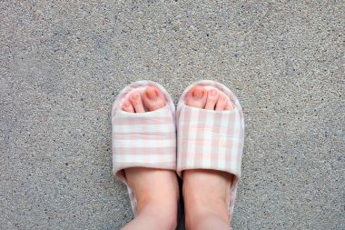 Damalı terlik, yakın çekim Womans pembe ev terlik ayak ve bacaklar arka plan