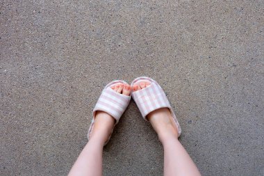 Damalı terlik, yakın çekim Womans pembe ev terlik ayak ve bacaklar arka plan