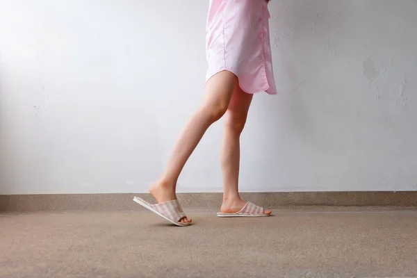 Traje de dormir rosa y zapatillas, primer plano de las mujeres Rosa zapatillas a cuadros de pie en el piso — Foto de Stock