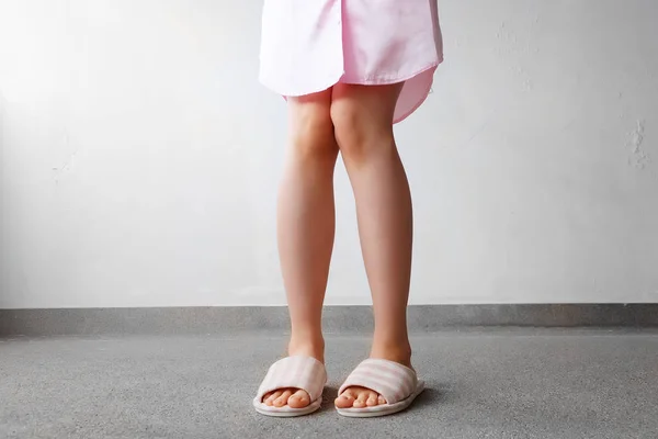 Traje de dormir rosa y zapatillas, primer plano de las mujeres Rosa zapatillas a cuadros de pie en el piso — Foto de Stock