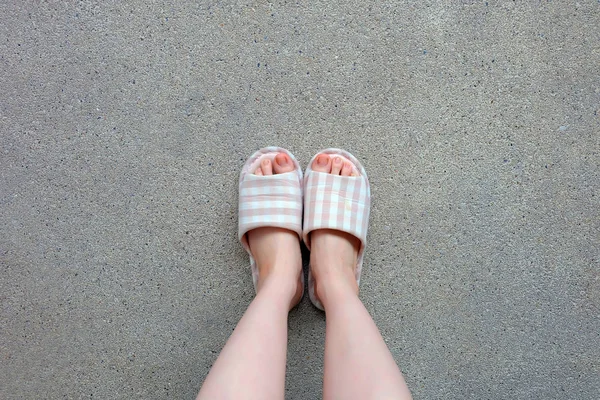 Kockás papuccsal, zár-megjelöl-ból Womans rózsaszín otthon papucsot láb és a lábak háttér — Stock Fotó