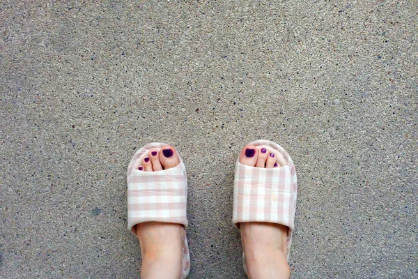 Karierte Hausschuhe, Selfie Frauen rosa Hausschuhe Füße (Nagellack) auf Betongrund — Stockfoto