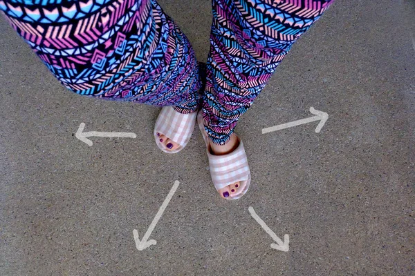 女人穿家庭拖鞋脚与箭头绘制选择方向的具体背景 — 图库照片