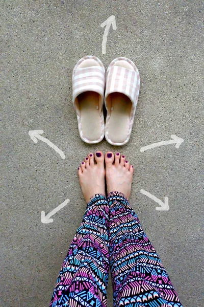 Womans Wear hem tofflor fötter med pilar dras val riktning på konkreta bakgrund — Stockfoto