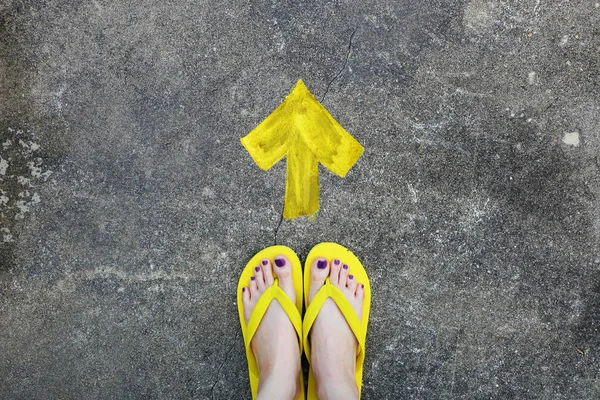 Направление "Желтые стрелы". Женские сандалии ноги с фиолетовой ногтей педикюр на цементном фоне — стоковое фото