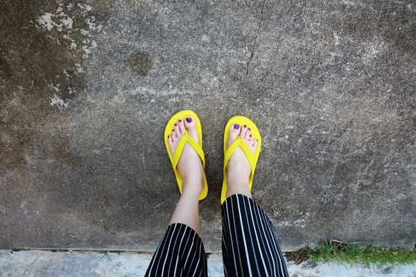 Sarı sandal. Selfie Womans sandalet ayak Violet ile çimento arka plan üzerinde boya pedikür tırnak