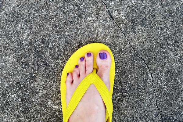 Sarı sandal. Selfie Womans sandalet ayak Violet ile çimento arka plan üzerinde boya pedikür tırnak