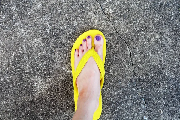 Sarı sandal. Selfie Womans sandalet ayak Violet ile çimento arka plan üzerinde boya pedikür tırnak