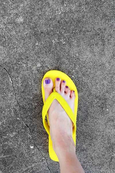 Sarı sandal. Selfie Womans sandalet ayak Violet ile çimento arka plan üzerinde boya pedikür tırnak