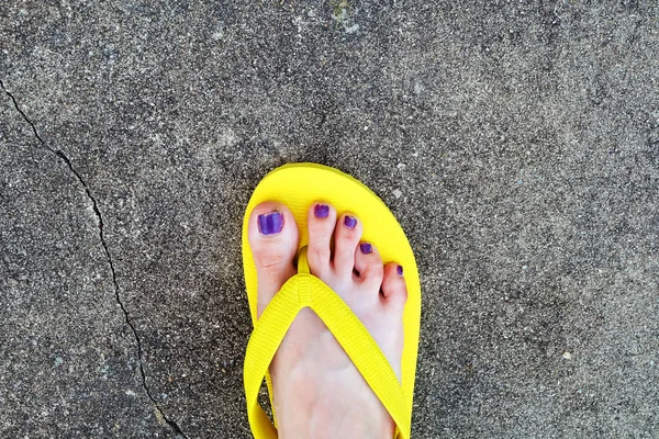 Gele sandalen. Selfie dames sandalen voeten met Violet nagel Pedicure van verf op Cement achtergrond — Stockfoto