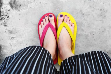 Kırmızı ve sarı floplar Flip. Selfie giyen kadın çimento üzerinde duran Flop Flip