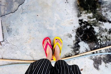 Kırmızı ve sarı floplar Flip. Selfie giyen kadın çimento üzerinde duran Flop Flip