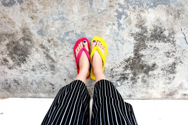 Kırmızı ve sarı floplar Flip. Selfie giyen kadın çimento üzerinde duran Flop Flip