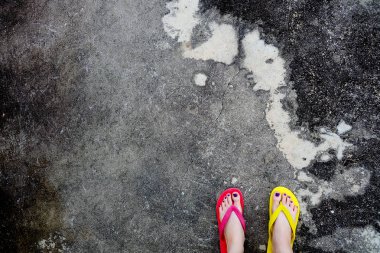 Kırmızı ve sarı floplar Flip. Selfie giyen kadın çimento üzerinde duran Flop Flip