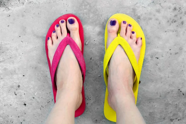 Infradito rosse e gialle. Selfie donna che indossa flip flop in piedi sul cemento — Foto Stock