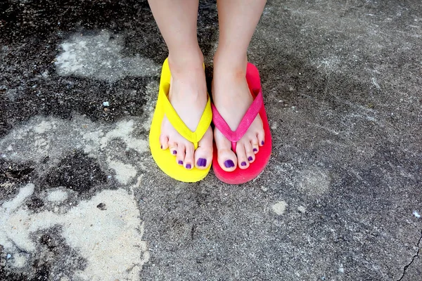 Infradito rosse e gialle. Selfie donna che indossa flip flop in piedi sul cemento — Foto Stock