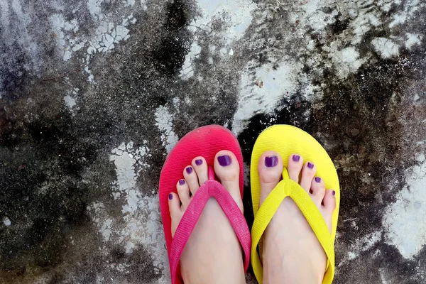 Kırmızı ve sarı floplar Flip. Selfie giyen kadın çimento üzerinde duran Flop Flip