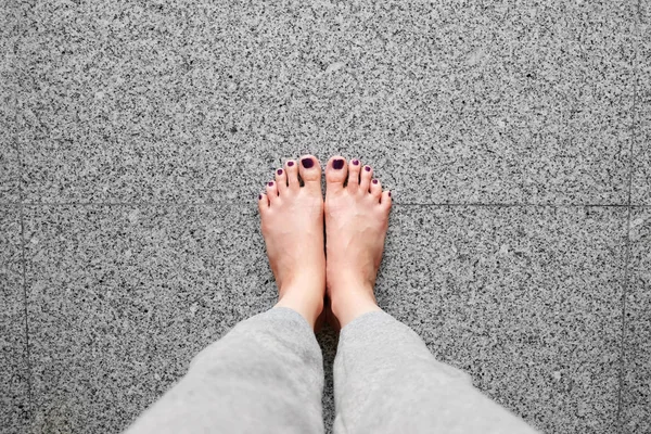 Barefeet with Nail Pedicure. Close Up Woman Legs Wear Gray Pants Standing On Gray Tile Background — Stock Photo, Image