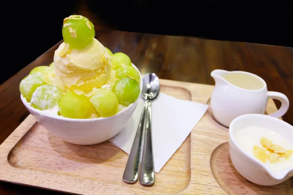 Meloen Bingsu Korean geschoren ijs Dessert op dienblad met Topping en melk op houten tafel achtergrond — Stockfoto