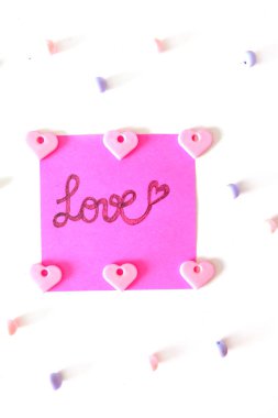 Pembe kağıt sopa not büyük bir beyaz arka plan üzerinde herhangi bir kullanım için yazılmış aşk metni ile.