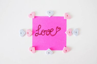 Pembe kağıt sopa not büyük bir beyaz arka plan üzerinde herhangi bir kullanım için yazılmış aşk metni ile.