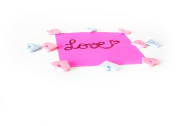 Pembe kağıt sopa not büyük bir beyaz arka plan üzerinde herhangi bir kullanım için yazılmış aşk metni ile.